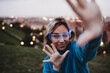 © Westend61 - Playful woman wearing smart glasses and gesturing at dusk