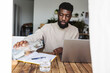 © Westend61 - Freelancer pouring water in glass near laptop at desk