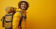 Cheerful young man is going on journey with backpack isolated on yellow background