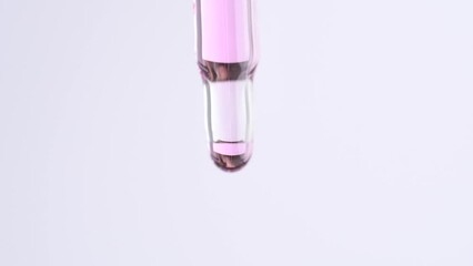 Wall Mural - Close up of pipette with pink cuticle oil. Drops of essential oil or serum fall from a glass pipette, macro.