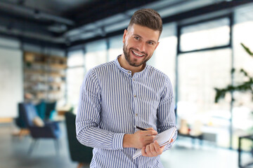 Wall Mural - Young modern business man analyzing data using laptop while working in the office.