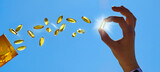 Fototapeta Sypialnia - Flying Vitamin D Pills with Woman Hand in Summer Sun - Panorama