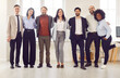 © Studio Romantic - Business portrait, successful group of businesspeople in modern office looking at camera. Happy diverse multiethnic businessmen, satisfied businesswomen standing as team share unity success, smiling