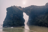 Fototapeta Morze - Cathedrals beach in Galicia, Spainn. Foggy landscape with Playa de Las Catedrales Catedrais beach in Ribadeo, Lugo on Santabrian coast. Natural archs of Cathedrals beach. Moody rock formations