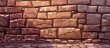 A detailed shot of a brown brick wall with cobblestone flooring. The texture of the brickwork contrasts with the smooth facade of the building material