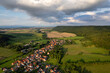 Aer ial view of a German village surrounded by meadows, farmland and forest. Thuringia, Germany.