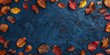 Vibrant autumn leaves scattered across a textured dark blue backdrop.