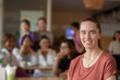 © Sophon_Nawit - Young adult German woman sits in the middle of the cafe, soft focus, blurred people in cafe background.