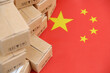Chinese export and tariffs concept. Flag of China and many shipping carton boxes.	