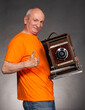 Senior man holding retro photocamera in studio