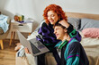red haired jolly woman spending quality time with her joyous boyfriend while at laptop at home