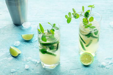 Poster - Mojito cocktail. Summer cold drink with lime, fresh mint, and ice. Cool beverage on a blue background with ingredients