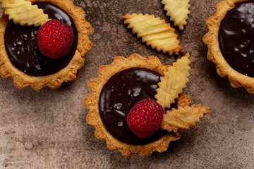 Wall Mural - Top view of Salted Chocolate Mini Tarts with chocolate ganache cream and raspberry.