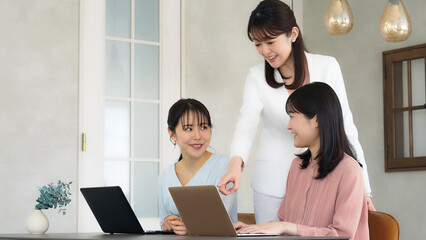 オフィスで会話するカジュアルウェアの女性グループ