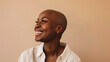 A bald woman with a shaved head after chemotherapy. Beautiful african american women standing isolated over beige background. Concept of supporting to all women suffering from cancer