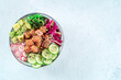 Tuna poke bowl with avocado, cucumbers, wakame, radish, and purple cabbage, overhead flat lay shot with copy space