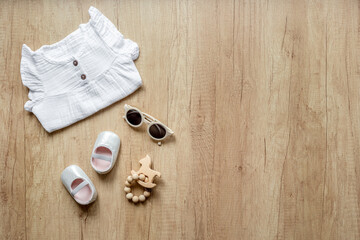 Wall Mural - Stylish white baby dress with sunglasses and accessories, top view