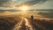A man is riding a bicycle down a dirt road. The sky is cloudy and the sun is setting