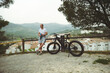 © Taras Grebinets - Full length portrait of a young man cyclist, standing nearby his electric bike, relaxing after biking in mountains