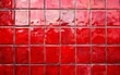 A scorched and weathered wall of red ceramic tiles, with a rugged, imperfect texture and intense color palette.