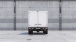 Rear view of a white delivery truck at an industrial loading bay