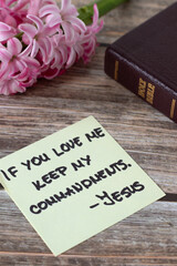 Wall Mural - If you love Me keep My commandments, Jesus Christ, handwritten quote with holy bible book and flower on wood. Close-up. Christian obedience to God, 10 commandments, biblical concept.