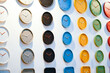 Colored rows of round clocks black blue yellow green red on a white wall.
