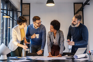 Wall Mural - An interracial engineers discussing blueprints and project at boardroom.