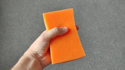 Man holding a sponge for washing the body in his hand and shows it