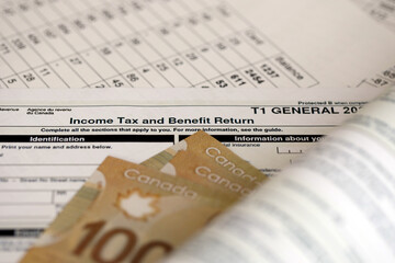 Wall Mural - Canadian T1 General tax form Income tax and benefit return lies on table with canadian money bills close up. Taxation and annual accountant paperwork in Canada