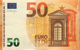 Fototapeta  - Fragment of one fifty euro money bill. Details of European union currency banknote of 50 euro close up