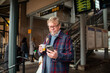 © Marko Geber - Senior man at the train station using smartphone
