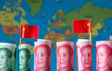Fototapeta Londyn - A Chinese world wide investment concept, Belt and Road Initiative, with rolls of Chinese yuan and national flags over a map of the world.