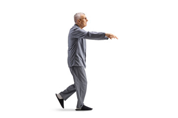 Wall Mural - Full length profile shot of a senior man in pajamas sleepwalking