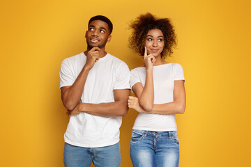 Wall Mural - Young couple day dreaming on orange background