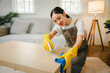 Young female housekeeper cleaning And wipe down the table with a microfiber cloth in the living room. young woman doing housework Housekeeping concept