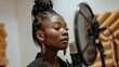 Focused black female standing and recording song near microphone equipment in studio