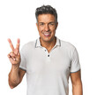 Middle-aged Latino man showing victory sign and smiling broadly.