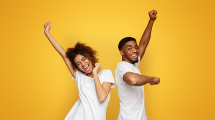 Wall Mural - Emotional black man and woman dancing on orange