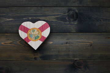 Wall Mural - wooden heart with national flag of florida state on the wooden background.