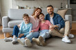 © Prostock-studio - Happy family sitting on the living room sofa
