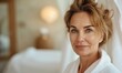 Skincare wellness spa procedures advertising concept with a happy cheerful middle aged woman wearing bathrobe at spa salon or hotel relax zone looking at camera
