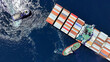 © aerial-drone - Aerial drone top down photo of tow - tug boat assisting by pulling container ship to dock to terminal port