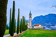 The scenic alley with cypress trees leads to Sant'Abbondio Chuch, Collina d'Oro, Switzerland