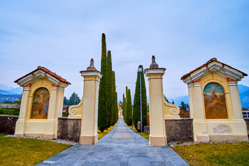 Wall Mural - The main entrance and the alley with cypress trees of Sant'Abbondio Chuch, Collina d'Oro, Switzerland