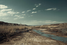 A Desolate Landscape With A Dry Riverbed And A Cloudy Sky