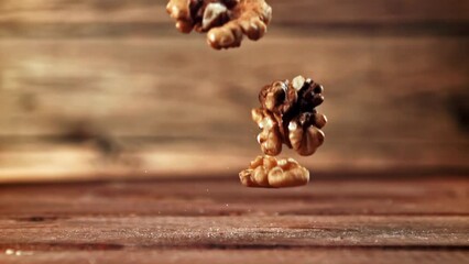 Wall Mural - Super slow motion peeled walnuts fall on the table. High quality FullHD footage