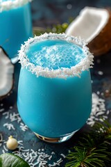 Wall Mural - Close-up of blue cold drink in a glass adorned with shredded coconut rim. Tasty drink to cool off on hot days on a dark marble table.
