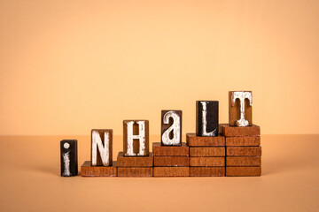 Wall Mural - content word in german. wooden alphabet letters on a light background