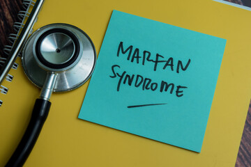 Wall Mural - Concept of Marfan Syndrome write on sticky notes with stethoscope isolated on Wooden Table.